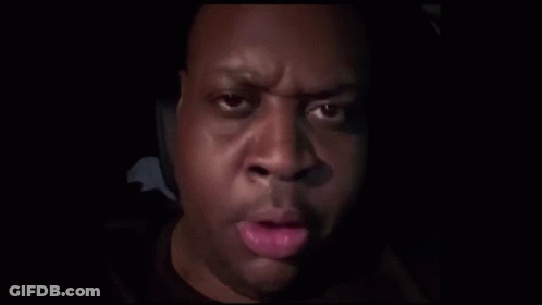 A Close Up Of A Man 'S Face With His Finger On His Mouth . GIF