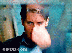 A Close Up Of A Man 'S Face With His Fist In The Air . GIF