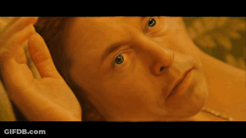 A Close Up Of A Man 'S Face With His Hand On His Face GIF