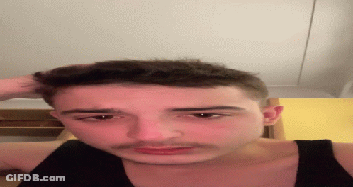 A Close Up Of A Man 'S Face With His Hand On His Head GIF