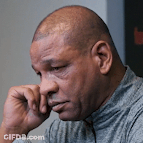 A Close Up Of A Man 'S Face With His Hand Resting On His Chin GIF