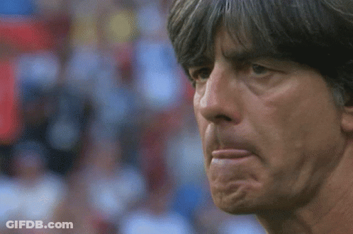 A Close Up Of A Man 'S Face With His Hand To His Mouth GIF