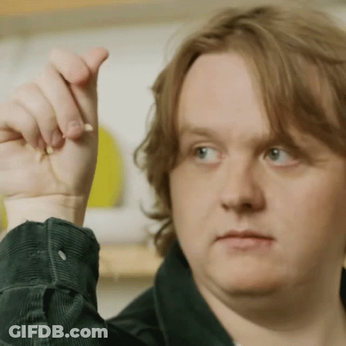A Close Up Of A Man 'S Face With His Hand Up In The Air GIF