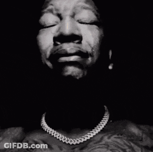 A Close Up Of A Man 'S Face With His Hands Folded In Prayer GIF