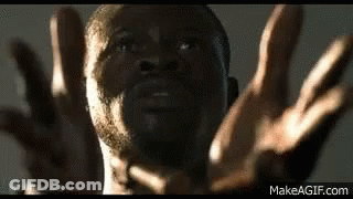 A Close Up Of A Man 'S Face With His Hands In The Air . GIF