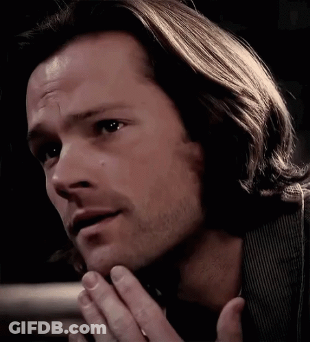 A Close Up Of A Man 'S Face With His Hands On His Chin GIF