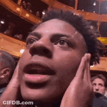 A Close Up Of A Man 'S Face With His Hands On His Face . GIF