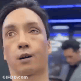 A Close Up Of A Man 'S Face With His Mouth Open And A Man In The Background . GIF