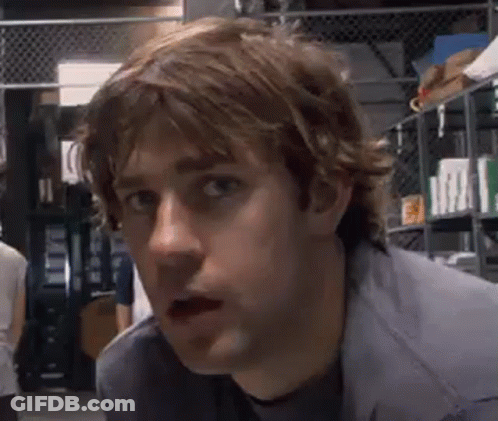 A Close Up Of A Man 'S Face With His Mouth Open In A Warehouse . GIF