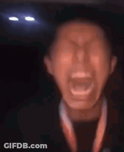 A Close Up Of A Man 'S Face With His Mouth Open GIF