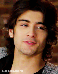 A Close Up Of A Man 'S Face With Long Hair And Earrings GIF