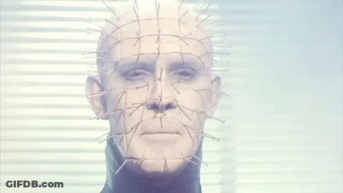 A Close Up Of A Man 'S Face With Nails In It . GIF