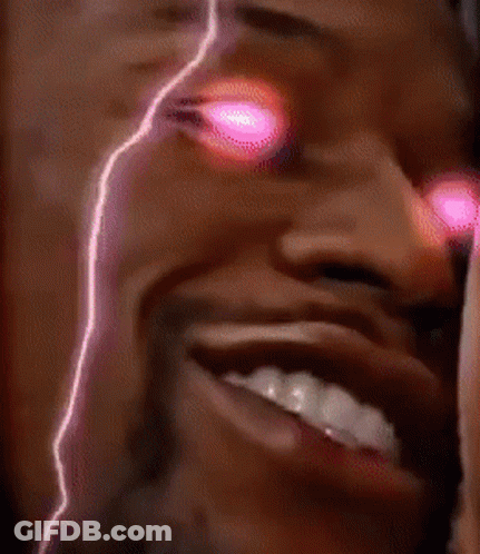 A Close Up Of A Man 'S Face With Pink Lights Behind Him GIF