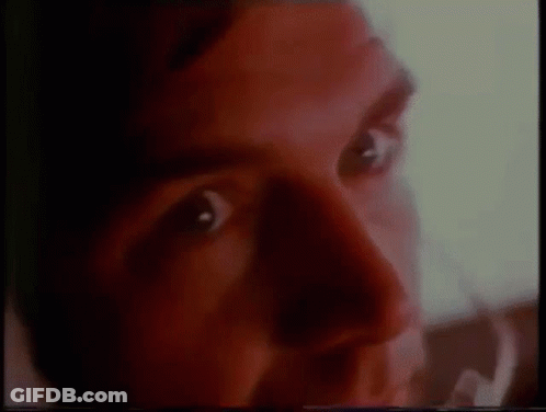 A Close Up Of A Man 'S Face With Red Eyes And A Blurred Background . GIF