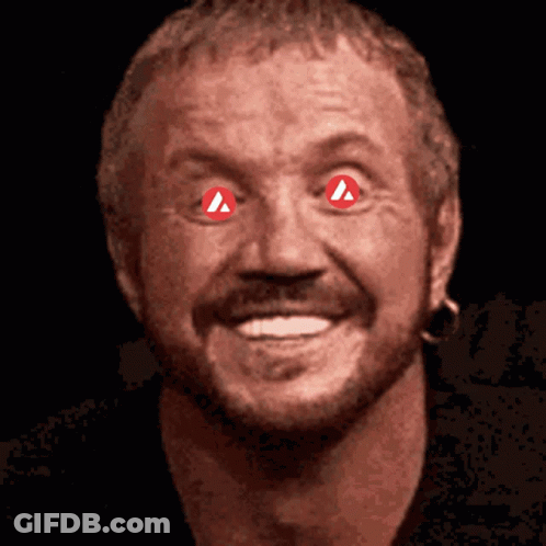 A Close Up Of A Man 'S Face With Red Eyes And A Red Triangle In His Eyes GIF