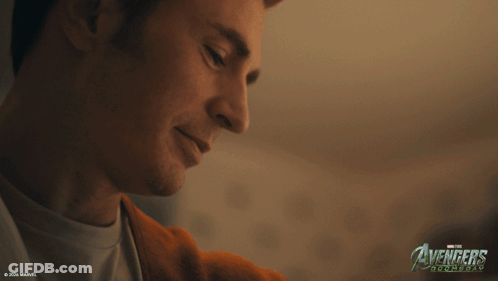 A Close Up Of A Man 'S Face With The Avengers Logo In The Corner GIF