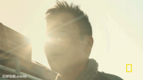 A Close Up Of A Man 'S Face With The National Geographic Logo In The Upper Right Corner GIF
