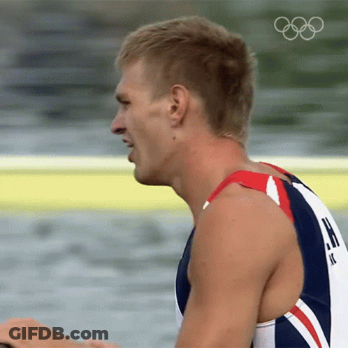 A Close Up Of A Man 'S Face With The Olympic Rings Visible GIF