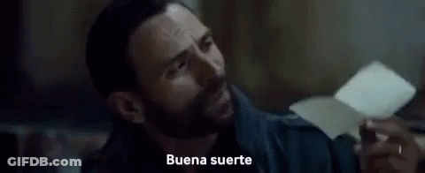 A Close Up Of A Man 'S Face With The Words `` Buena Suerte '' Written On The Screen Behind Him . GIF