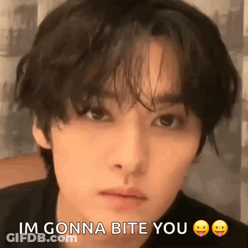A Close Up Of A Man 'S Face With The Words `` Im Gonna Bite You '' Written On It . GIF