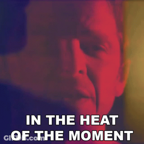A Close Up Of A Man 'S Face With The Words " In The Heat Of The Moment " Below It GIF