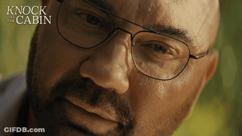 A Close Up Of A Man 'S Face With The Words " Knock At The Cabin " Behind Him GIF