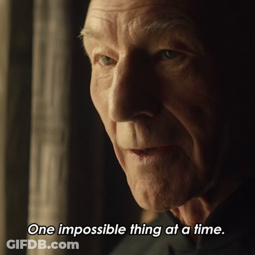 A Close Up Of A Man 'S Face With The Words One Impossible Thing At A Time Below It GIF