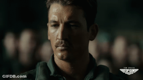 A Close Up Of A Man 'S Face With The Words Tom Cruise 'S Top Gun Marines On The Bottom GIF
