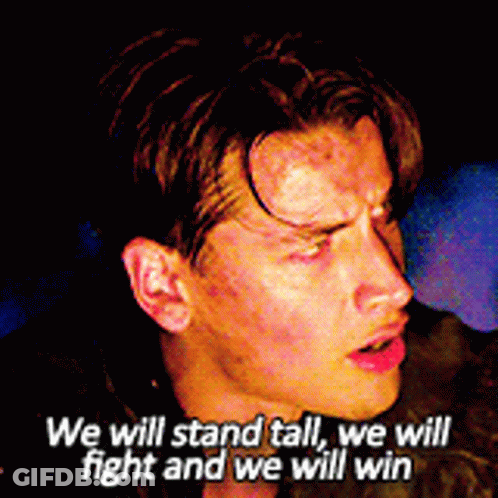 A Close Up Of A Man 'S Face With The Words We Will Stand Tall We Will Fight And We Will Win Above Him GIF