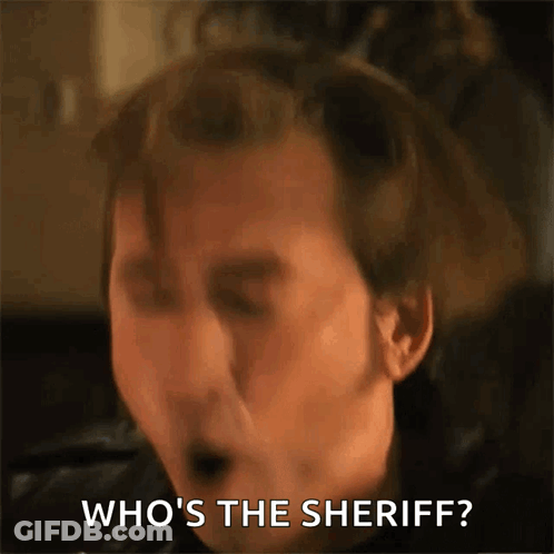 A Close Up Of A Man 'S Face With The Words Who 'S The Sheriff Behind Him GIF