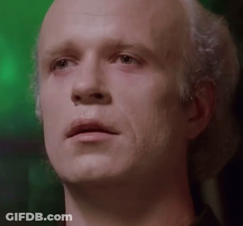 A Close Up Of A Man 'S Face With White Hair And A Green Background GIF