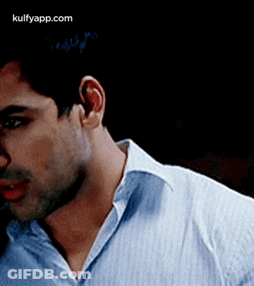 A Close Up Of A Man 'S Neck And Ear In A Blue Shirt . GIF
