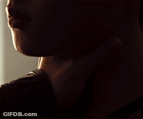 A Close Up Of A Man 'S Neck And Face In The Dark GIF