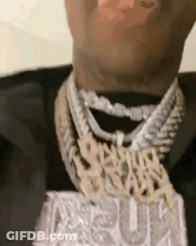 A Close Up Of A Man 'S Neck Wearing A Necklace With A Pendant . GIF