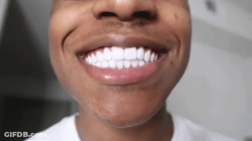 A Close Up Of A Man 'S Teeth With A White Shirt On GIF