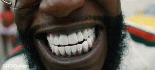 A Close Up Of A Man 'S Teeth With Rhinestones GIF