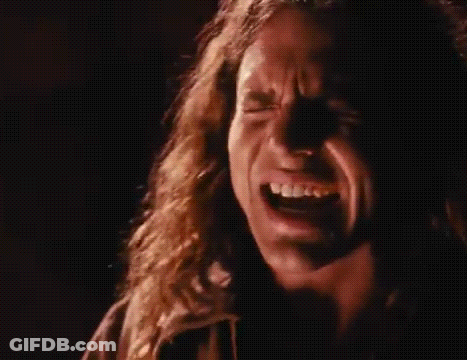 A Close Up Of A Man Screaming Into A Microphone In A Dark Room . GIF