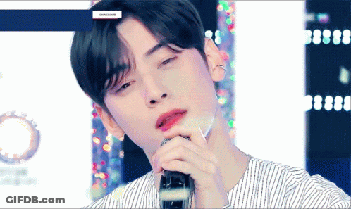 A Close Up Of A Man Singing Into A Microphone . GIF