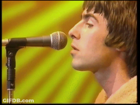 A Close Up Of A Man Singing Into A Microphone . GIF