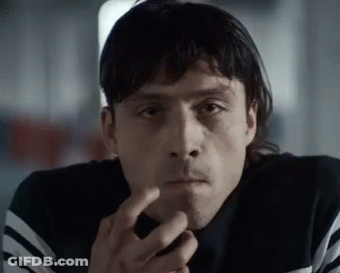 A Close Up Of A Man Smoking A Cigarette And Looking At The Camera . GIF