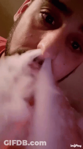 A Close Up Of A Man Smoking A Cigarette With The Words Imgplay On The Bottom Right GIF