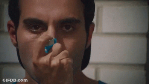 A Close Up Of A Man Using An Inhaler On His Nose GIF