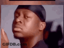 A Close Up Of A Man Wearing A Bandana And A Hat Making A Funny Face . GIF