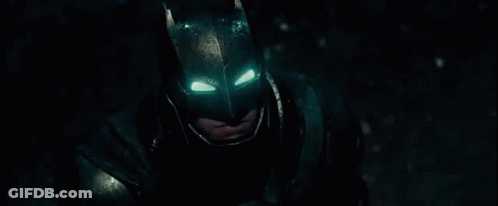 A Close Up Of A Man Wearing A Batman Mask With His Eyes Glowing . GIF