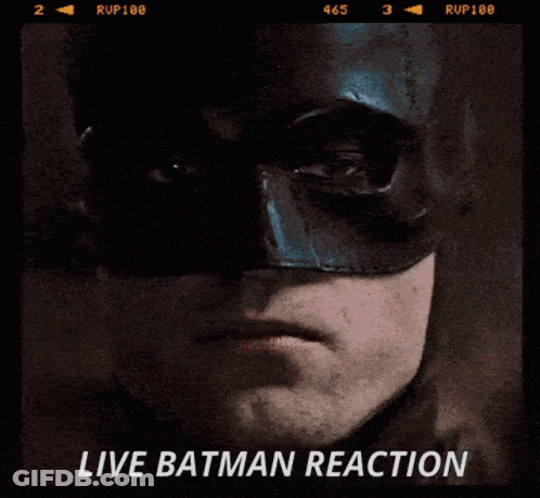 A Close Up Of A Man Wearing A Batman Mask With The Words Live Batman Reaction On The Bottom GIF