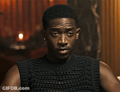 A Close Up Of A Man Wearing A Black Sleeveless Sweater GIF