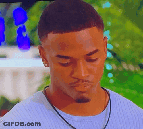 A Close Up Of A Man Wearing A Blue Sweater And A Black Necklace GIF