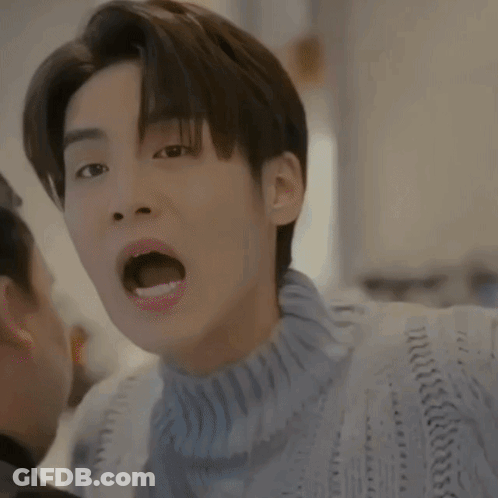 A Close Up Of A Man Wearing A Blue Sweater With His Mouth Open GIF