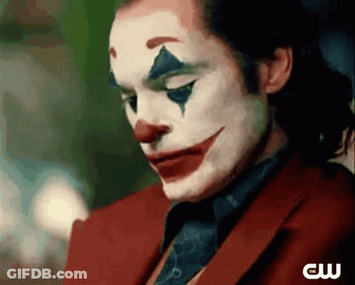 A Close Up Of A Man Wearing A Clown Costume And A Red Suit And Tie . GIF