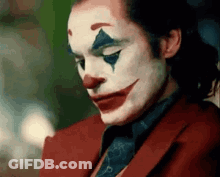 A Close Up Of A Man Wearing A Clown Costume And A Red Suit . GIF